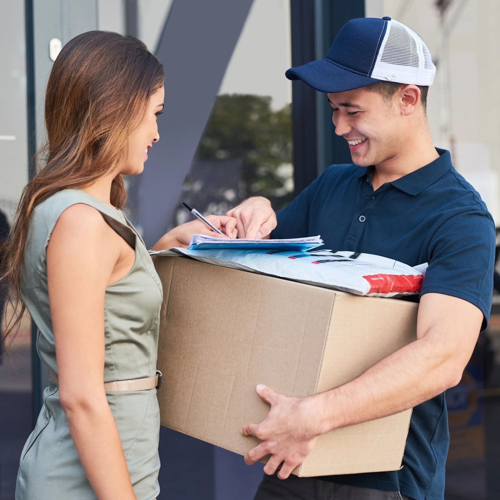 Delivery worker handing a package to a smiling customer